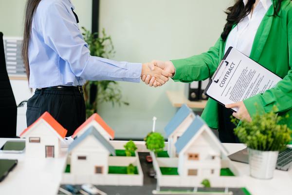 Property managers shaking hands over rental contract